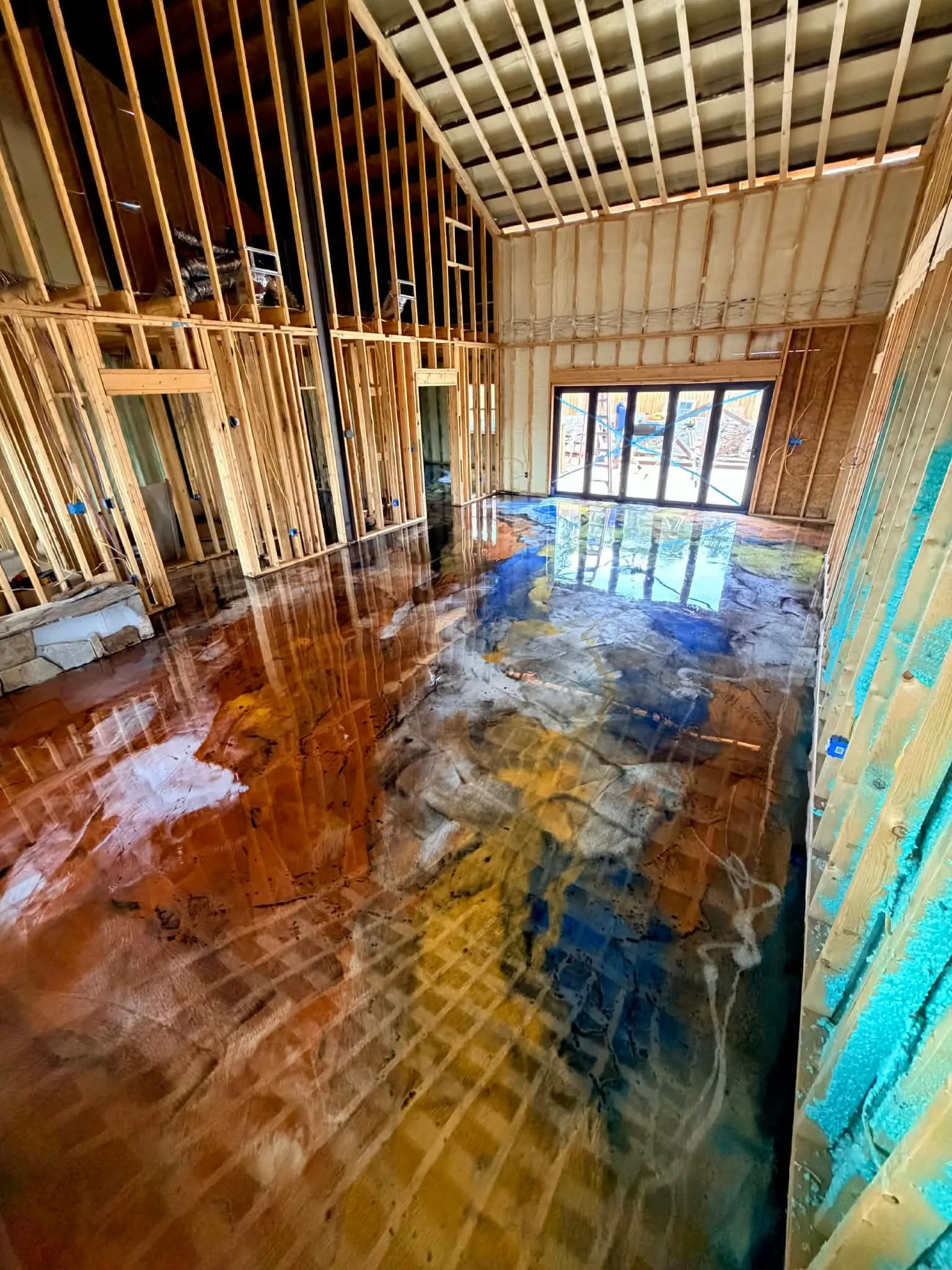 Finished copper, blue, gold, black, and pearl luxury resin floor spanning the Sweetwater home's great room