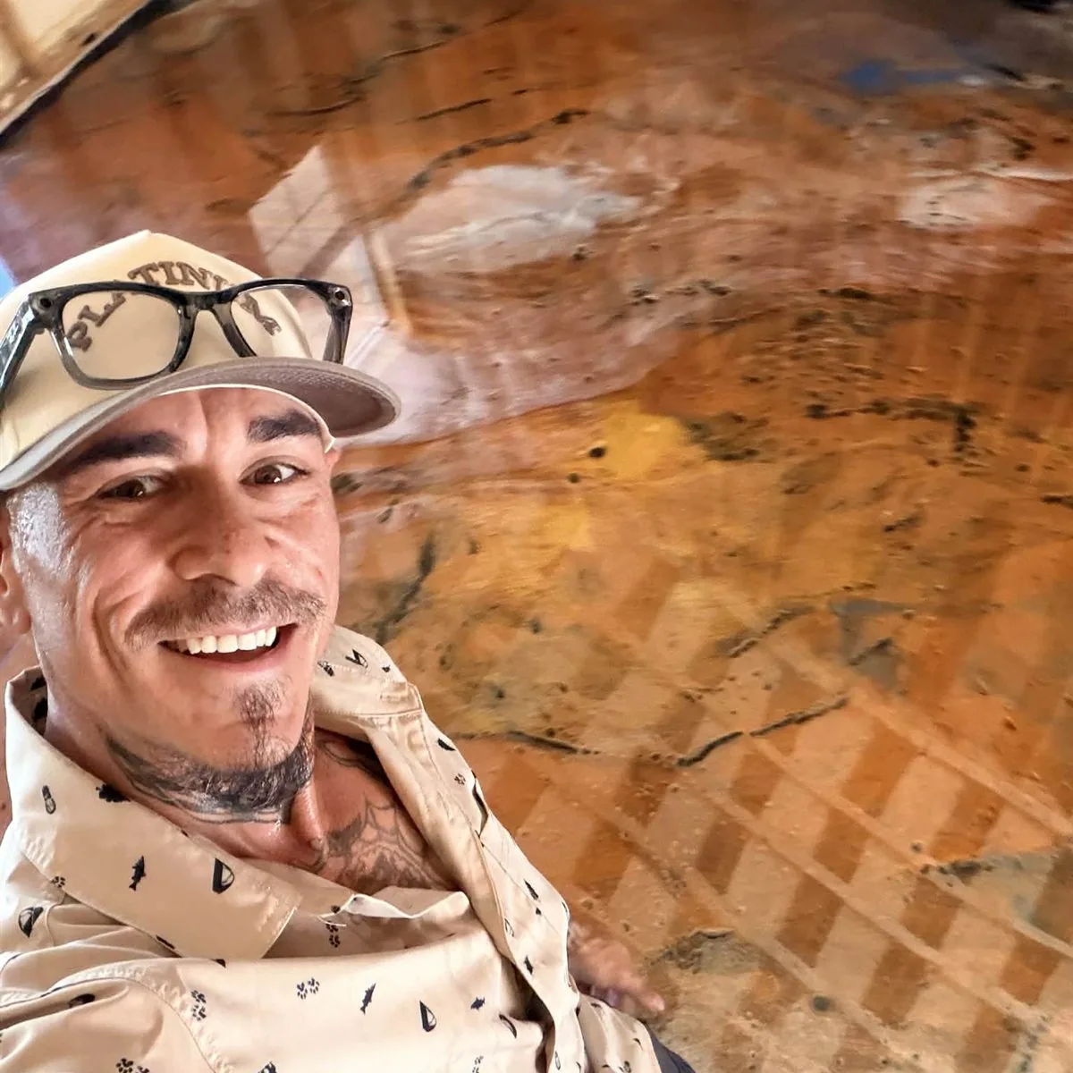 Blake Mendoza, owner of Elite Epoxy, smiling beside a copper-toned metallic epoxy floor